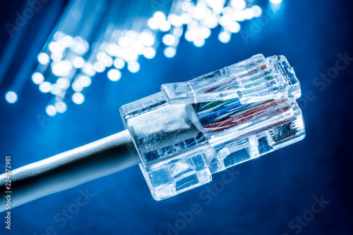 Network cable and optical fibers with lights in the ends at the background.
