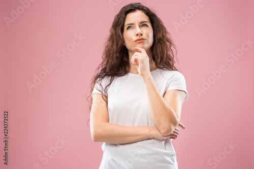 Remember all. Let me think. Doubt concept. Doubtful, thoughtful woman remembering something. Young emotional woman. Human emotions, facial expression concept. Studio. Isolated on trendy pink. Front photo