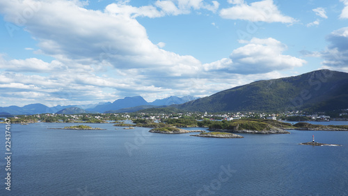 Horizontal shot with perspective from fjord, at high, vantage point, of the city of Bergen, unusual landscape with scattered villages, remote islets, solitary houses surrounded by mountains, Norway