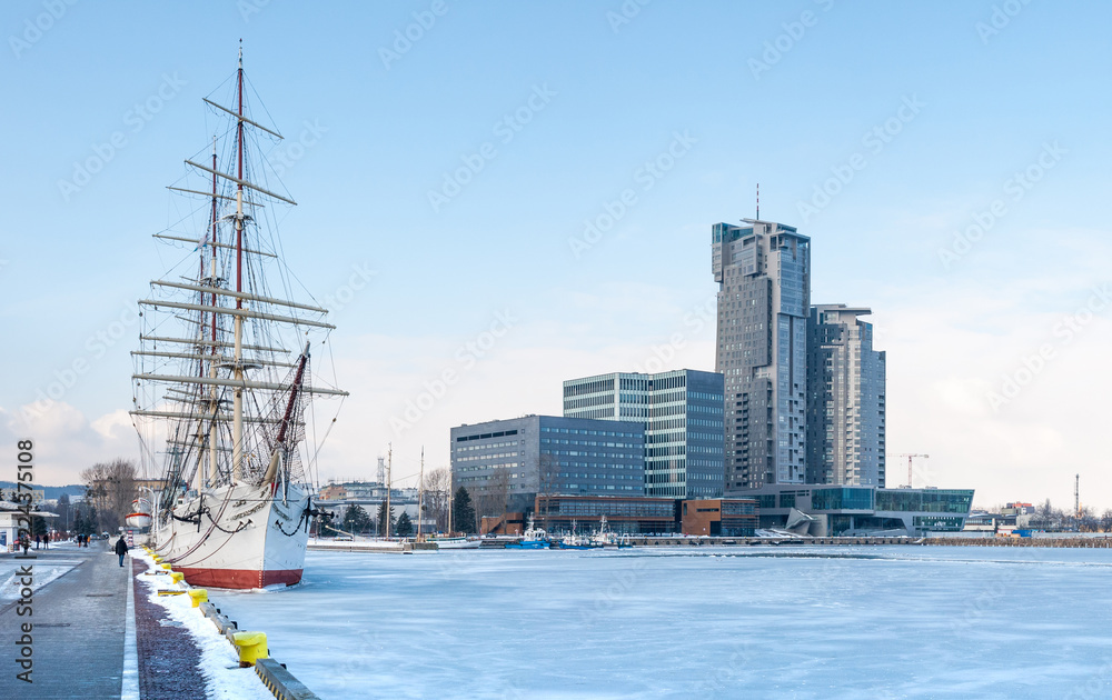 Fototapeta premium Old ship on frozen sea and busyness building