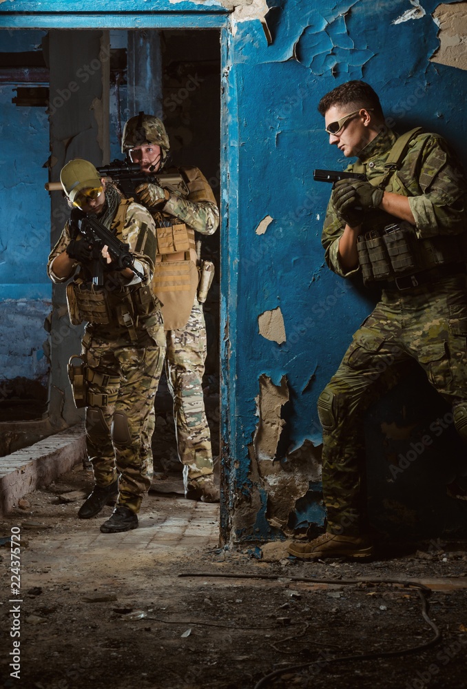 the people in uniform with weapons in the ruins