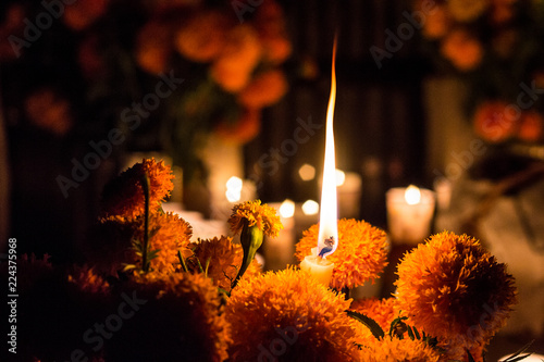 Day of the dead in Janitzio, Michoacan, Mexico. Candle among flowers mexican celebration. Cempasuchil flowers and altar candles in a cemetery