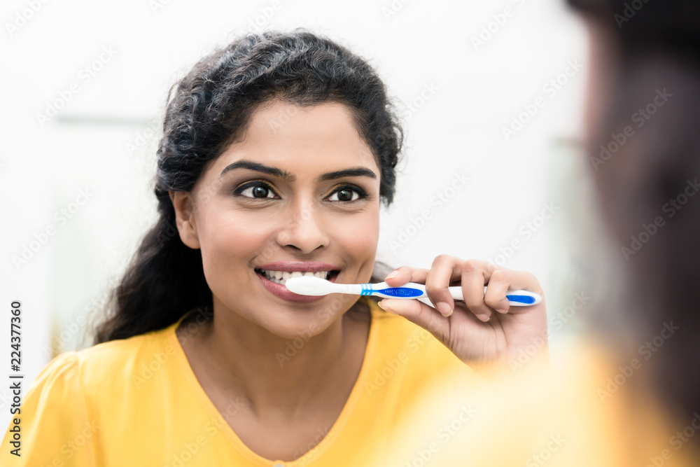 Close-up of a smiling woman brushing teeth Close-up of a smiling woman brushing teeth