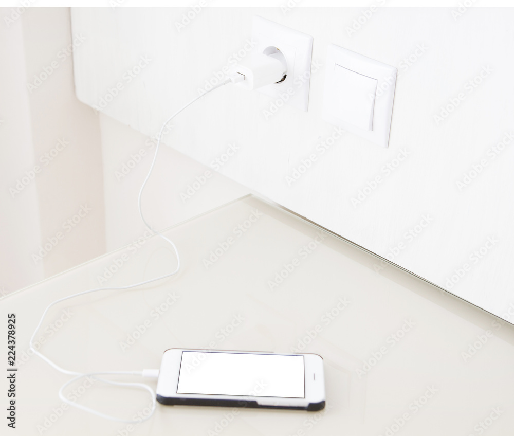 Fototapeta premium charging smartphone, cellphone on wooden table, blank screen mobile phone. Selective focus.Copy space, blank, mock up,top view