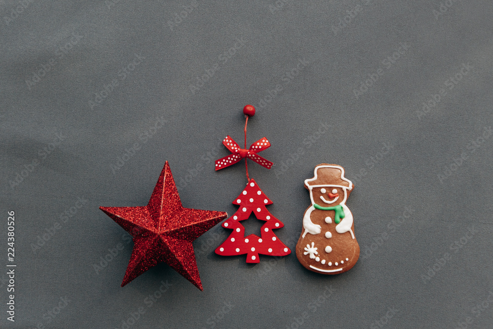 Christmas toys and gingerbread in the shape of a snowman on a gray background. Christmas or New Year's concept.