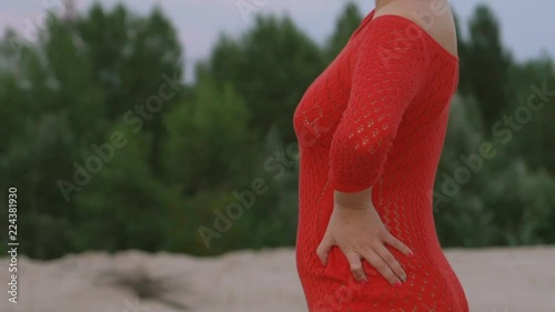 charming red-haired beauty in the desert. woman 30 years of sexually dancing in the sand. eastern motif. an oriental girl in a red cloth and a turban. large gold earrings .Slow motiom photo