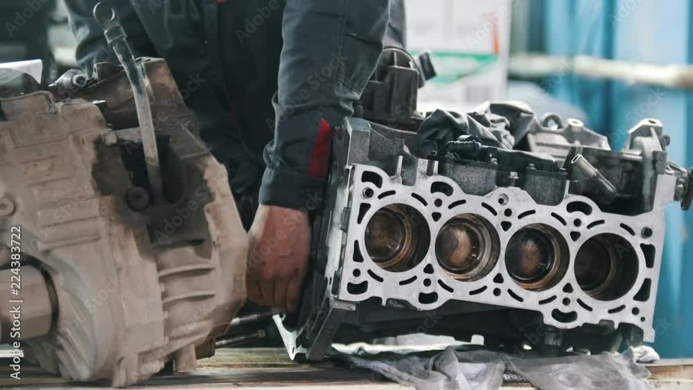 Mechanic repairs the valve block of the car engine Mechanic repairs the valve block of the car engine