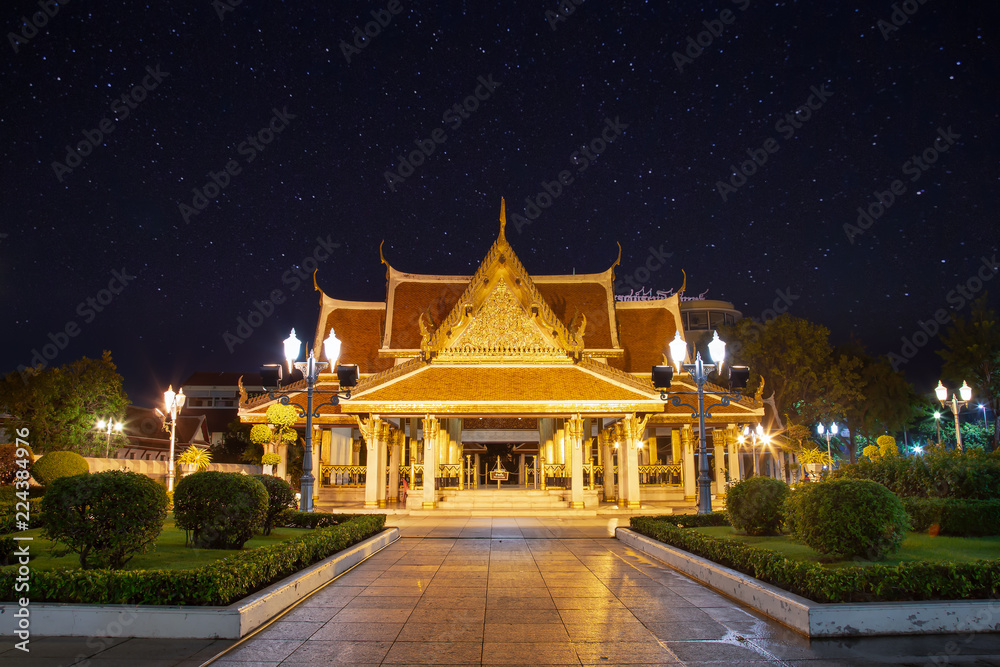 Landscape of the royal temple or Ratchanatda temple at night with yellow flowers at Bangkok, Thailand. It is popular with both Thai and foreign tourists. The beauty of Bangkok at night concept.