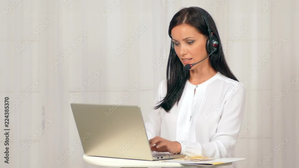 The girl in the headphones is working at the computer. The girl in the headphones is working at the computer.
