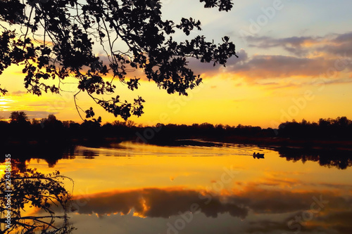 Evening  sunset  river  reflection of clouds in the water  boat with fisherman