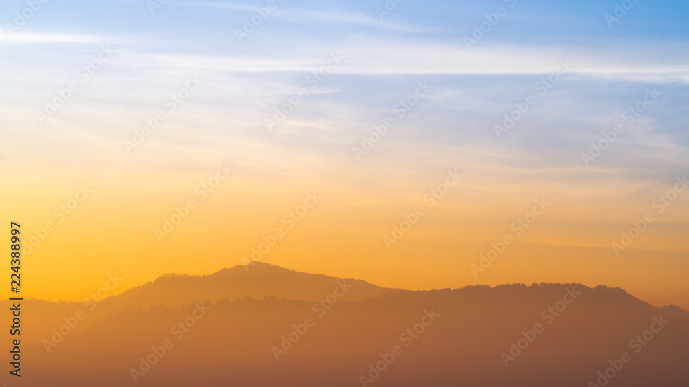 Blue and orange sunlight sky of sunrise in morning with the mountains