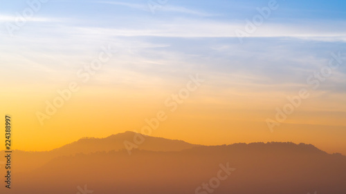 Blue and orange sunlight sky of sunrise in morning with the mountains