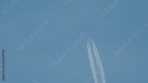 Airplane in flight, making a white stripe in the blue sky, called a contrail, condense trail or vapour trail