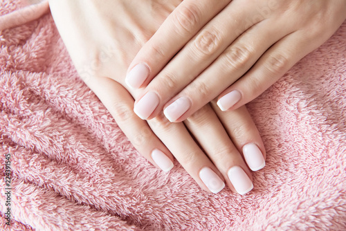 Manicured hands on towel. French manicure.