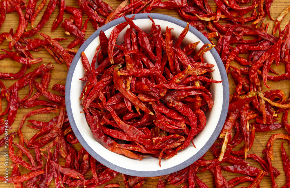 Fototapeta premium Dried red chillies in plate on wooden background.
