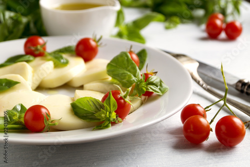 Caprese salad with ripe tomatoes and mozzarella with fresh Basil leaves. Italian food.