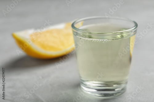 Glass with mouthwash and lemon on light background. Teeth care