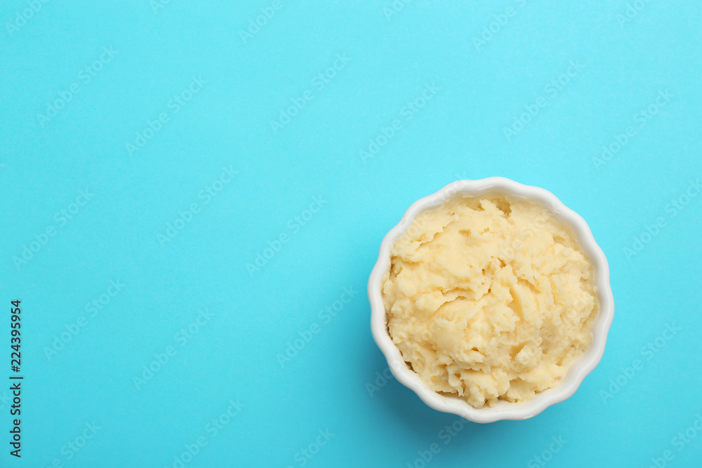 Bowl with tasty mashed potatoes and space for text on color background, top view Bowl with tasty mashed potatoes and space for text on color background, top view