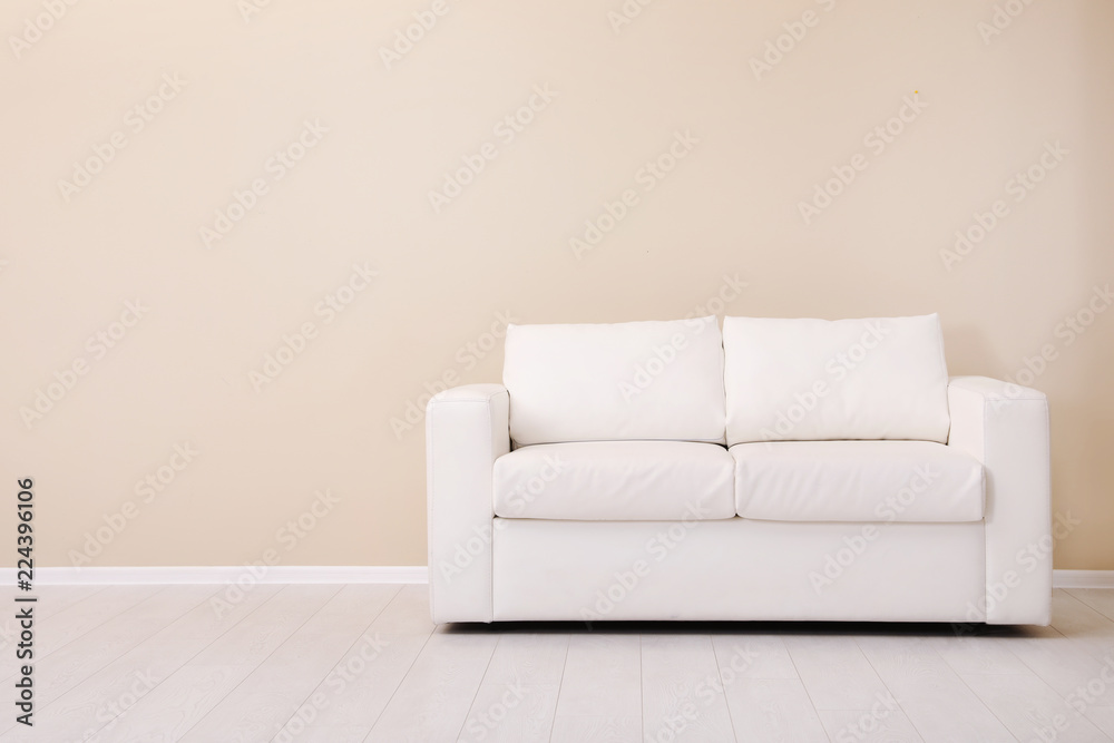 Naklejka premium Room interior with comfortable sofa near color wall. Space for text