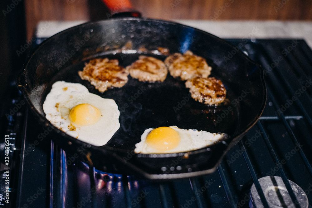 Sausage and eggs being cooked in cast iron skillet on a gas stove. Stove from RV. Full time RV lifestyle Sausage and eggs being cooked in cast iron skillet on a gas stove. Stove from RV. Full time RV lifestyle