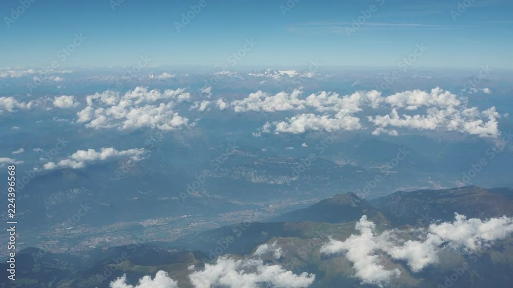 Flying over the European Alps during summer season. Aerial view from the airplane window Flying over the European Alps during summer season. Aerial view from the airplane window