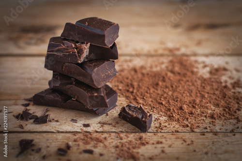 Close-up of stacked dark chocolate on wooden background 
