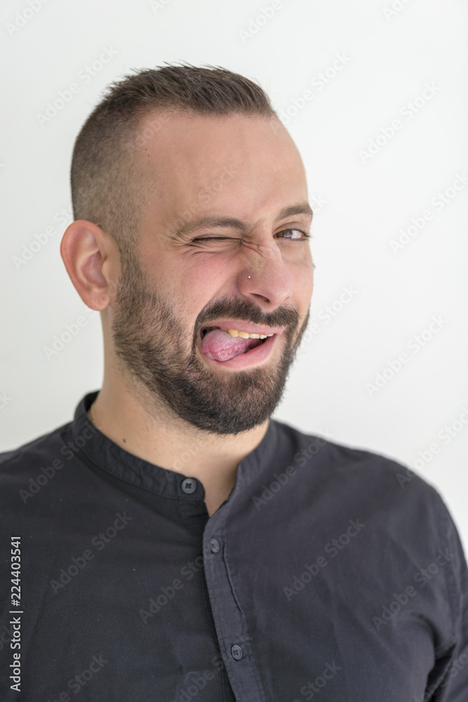 young businessman with tattoo, black t-shirt, beard and black hair, and with a white background young businessman with tattoo, black t-shirt, beard and black hair, and with a white background
