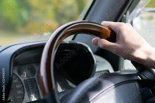 view of the hand of the people, the driver, holding the wheel of the car, close-up