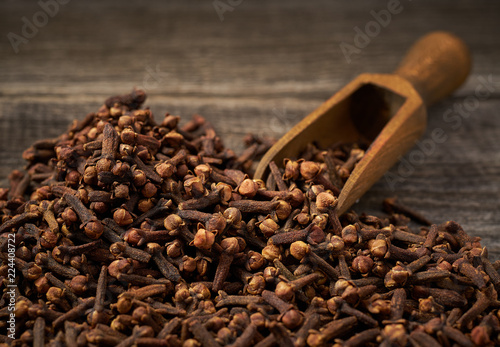 Dried cloves in a wooden shovel close-up photo