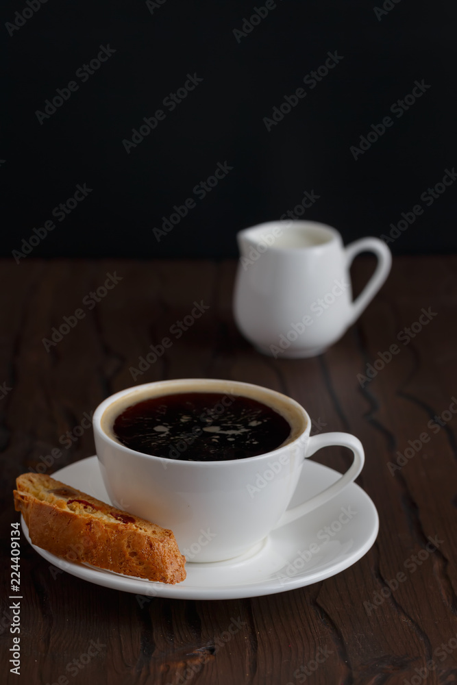 coffee and biscotti on a wooden table, dark background coffee and biscotti on a wooden table, dark background
