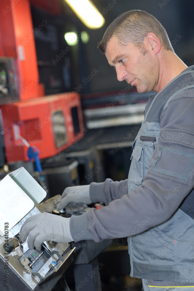 handsome worker using machine in factory handsome worker using machine in factory
