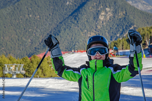 Male teenager skier with hands up