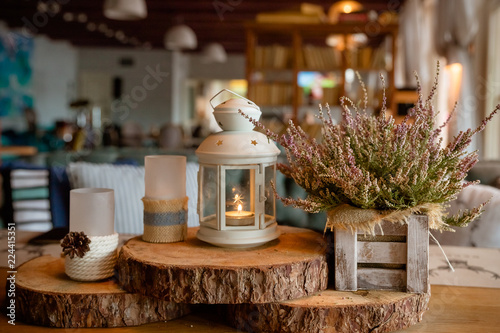 Beautiful stylish autumn table decoration .white - pink heather in autumn basket.Candles and lamps. stylish table catering.Still life details,cozy concept.Restaurant interior decor in warm and brown