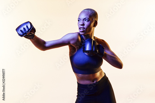 Fierce woman boxing, one arm stretched out 