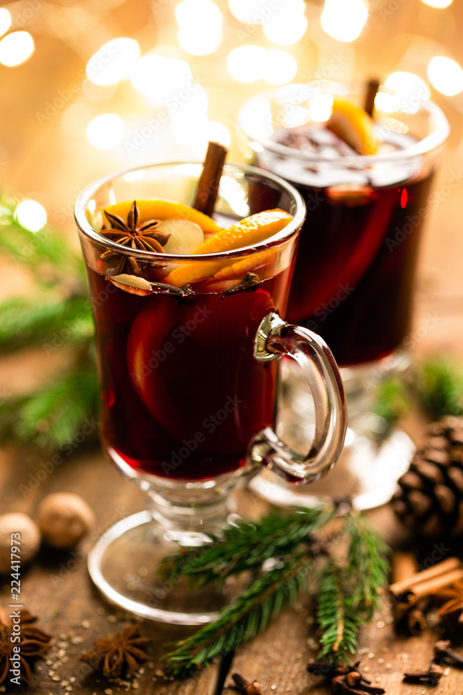 Christmas mulled red wine with spices and oranges on a wooden rustic table. Traditional hot drink at Christmas Christmas mulled red wine with spices and oranges on a wooden rustic table. Traditional hot drink at Christmas