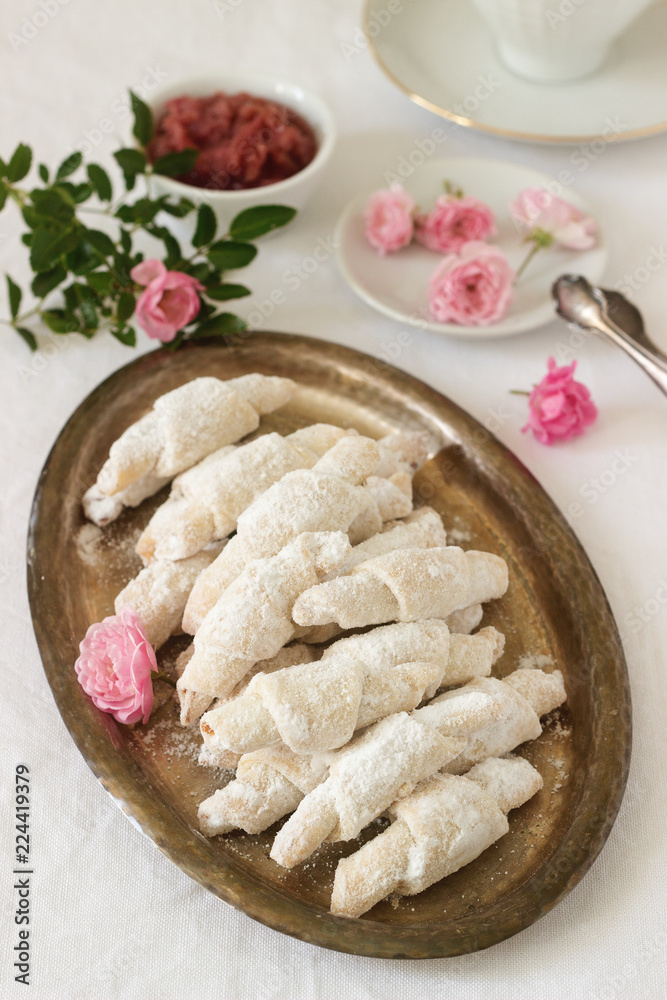 Traditional Romanian or Moldavian shortcake cookies with jam stuffing and a cup of tea on the light background. Traditional Romanian or Moldavian shortcake cookies with jam stuffing and a cup of tea on the light background.