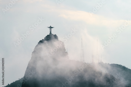 Christ the Redeemer statue on Corcovado hill covered with clouds and fog in Rio de Janeiro, Brazil