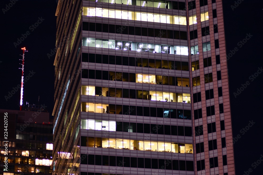 Office building at night. Late night at work. Glass curtain wall office building