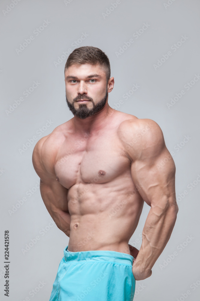 Strong Athletic Man Fitness Model Torso showing six pack abs. isolated on grey background with copyspace Strong Athletic Man Fitness Model Torso showing six pack abs. isolated on grey background with copyspace