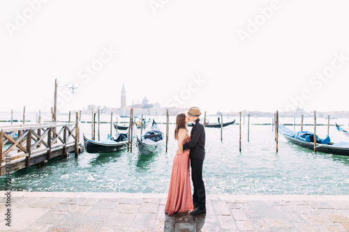 Italy beauty, pretty girl and boy with San Giorgio Maggiore and boat behind, Venezia, Venice