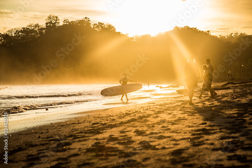 sunset on the beach and surfer © AnaCristina