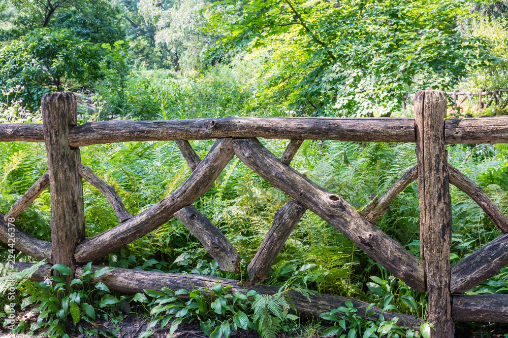 Old fence made of thick branches of trees Old fence made of thick branches of trees