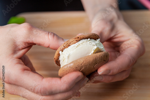 Macro Closeup of Female Hands Making a Vanilla Ice Cream Sandwich with Ginger Cookies