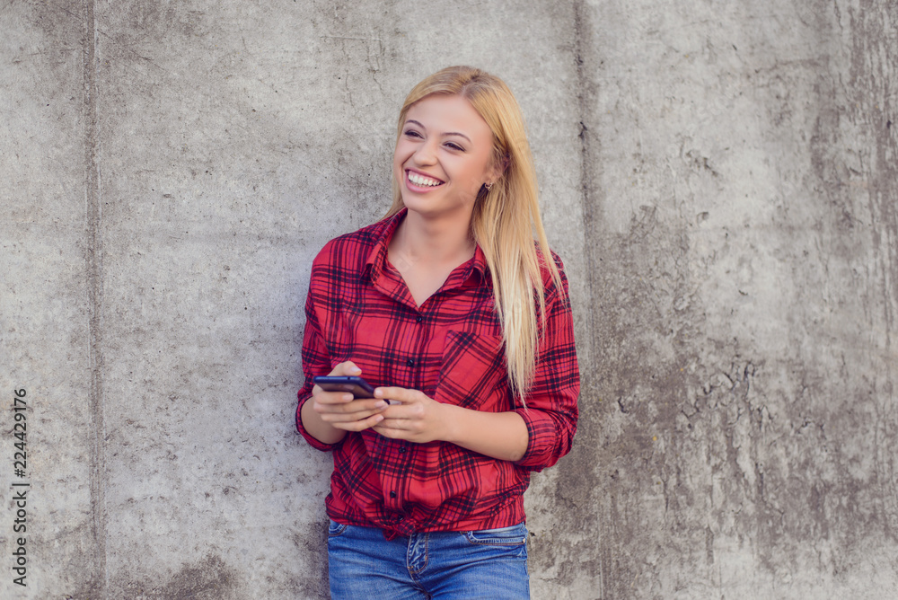 Happy smiling woman using her smartphone for typing with friend Happy smiling woman using her smartphone for typing with friend