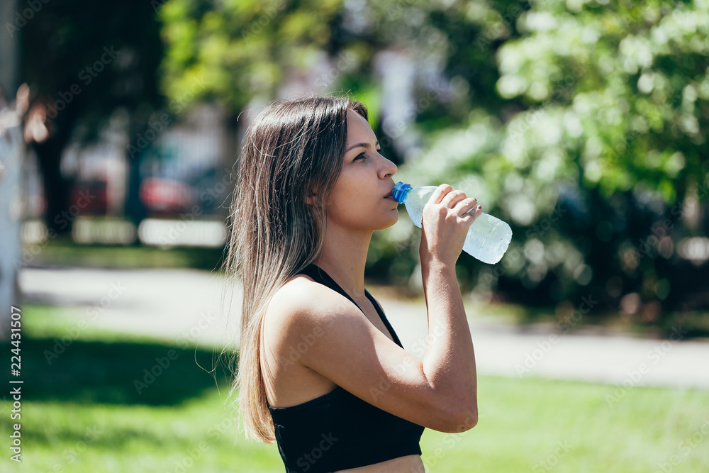 Portrait of fit and sporty young woman drinking water Portrait of fit and sporty young woman drinking water