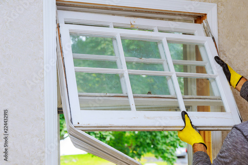 Hand of a worker replacing the old wooden window
