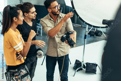 Photographer working with his team during a photo shoot in a stu photo