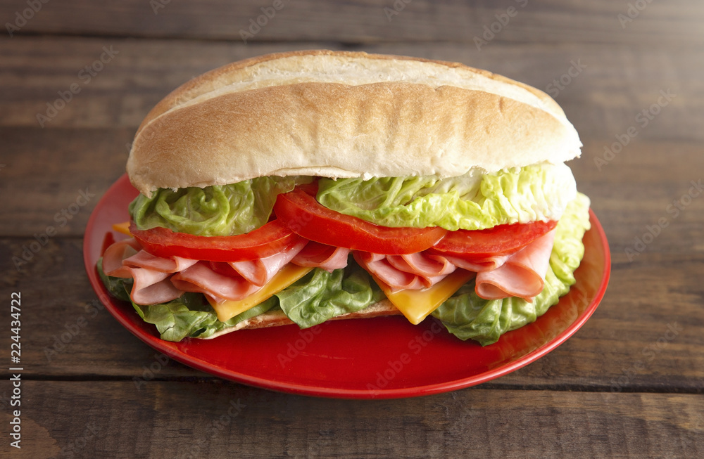 Ham Sandwich with Lettuce Cheese and Tomatoes on a White Bun