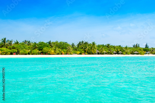 Beautiful sandy beach with sunbeds and umbrellas in Indian ocean, Maldives island © Myroslava