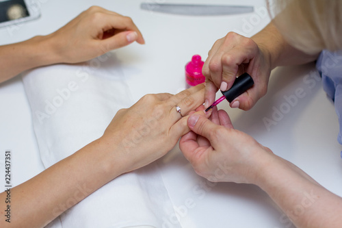 A specialist does a manicure in a beauty salon